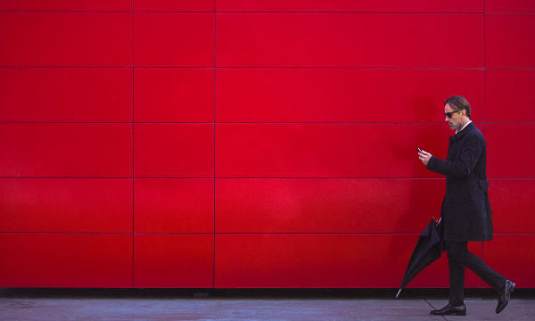 business man in front of red coloured wall